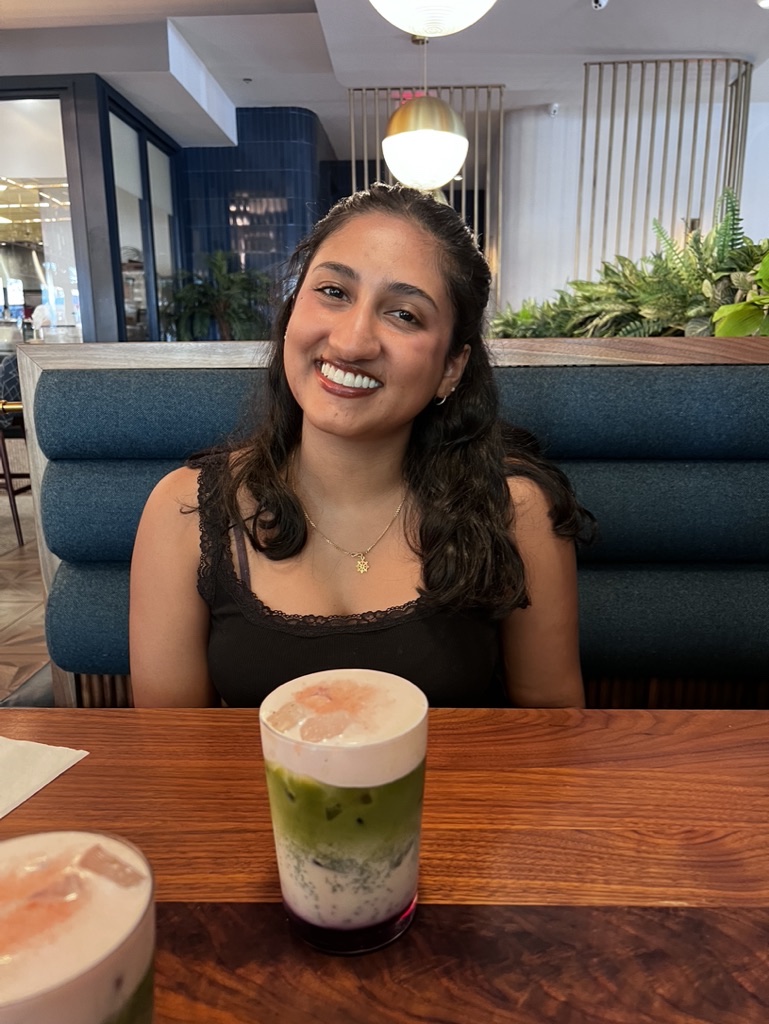 Randilu smiling, seated at a restaurant table